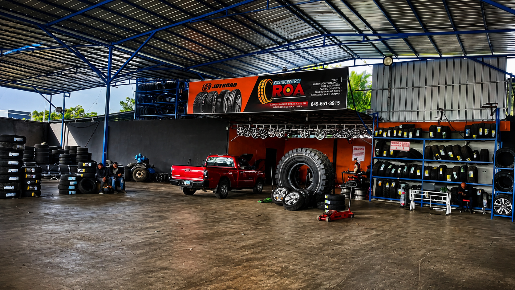 Interior del taller de Gomicentro Roa con neumáticos, aros y vehículos en servicio